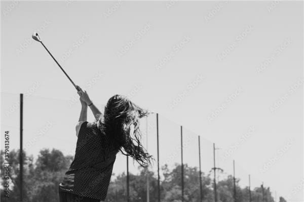 Female golfer following through on a swing