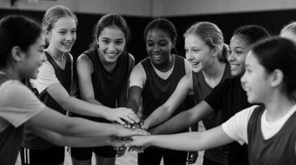 Female athletes joining hands in a team huddle